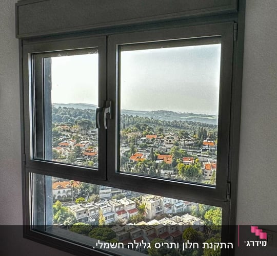 חלון אלומיניום עם נוף עירוני ברקע